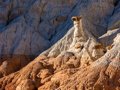White and Chocolate Hoodoos Against Blue Cliffs